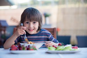 niño saludable comiendo pasta de lunch