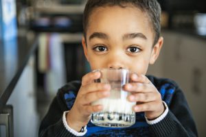 Niño sano tomando leche con vitaminas